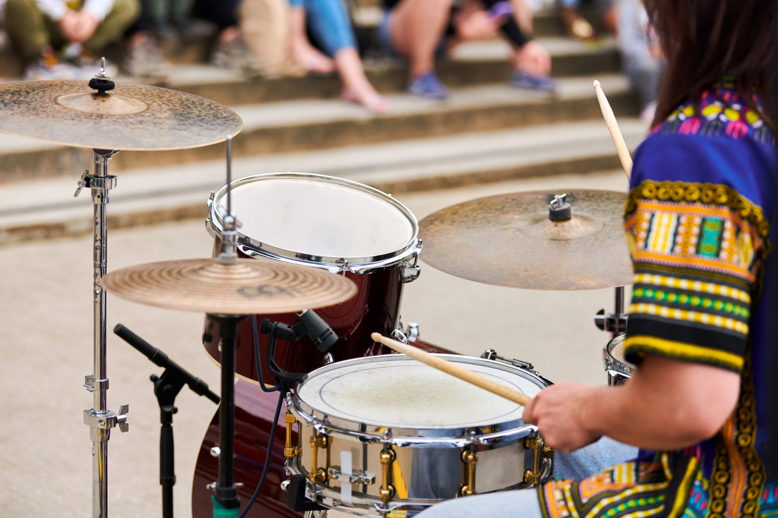Drummer man playing drums percussion with drumsticks, male hands playing drum set on concert stage outdoor, close up. Drum sticks and drums, musical concept with working drum kit